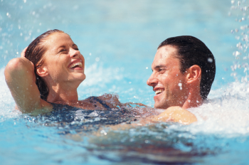 1 Mann und eine Frau im Wasser welche glücklich schwimmen